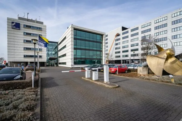 Bedrijfsgebouwen van Smit Lamnalco en Boskalis aan de Waalhaven met een grote scheepsschroef als kunstobject op de voorgrond.